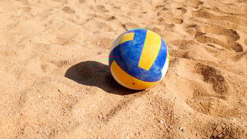 closeup-photo-volleyball-ball-lying-sand-sea-beach